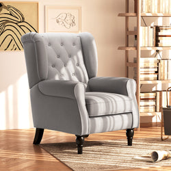 Gray armchair in a room with a bookshelf and decorative items